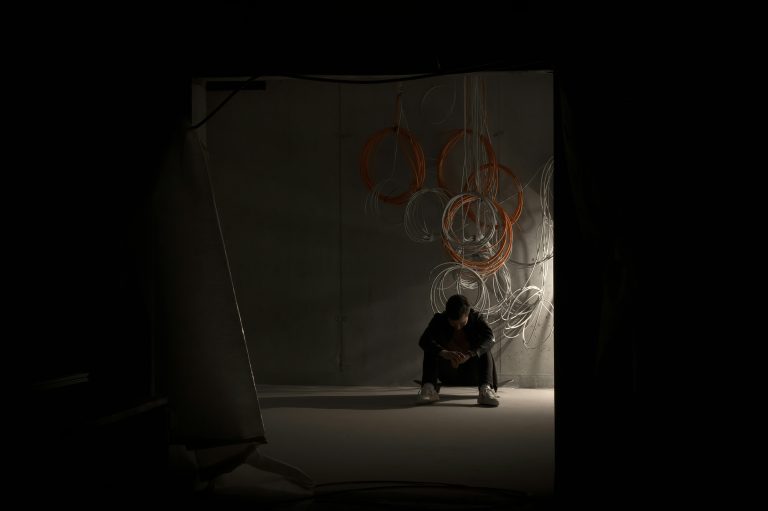 Man sitting in the dark, symbolizing burnout and motivation crash.