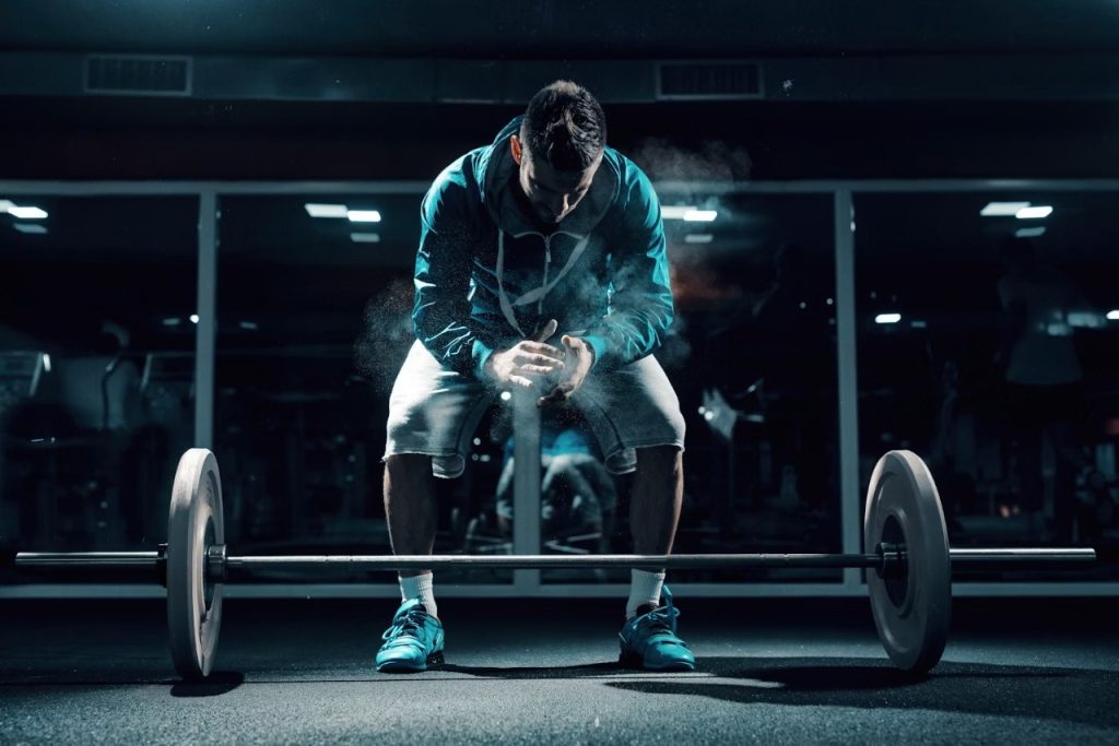 Man with a barbell like a weapon, representing war against weakness.
