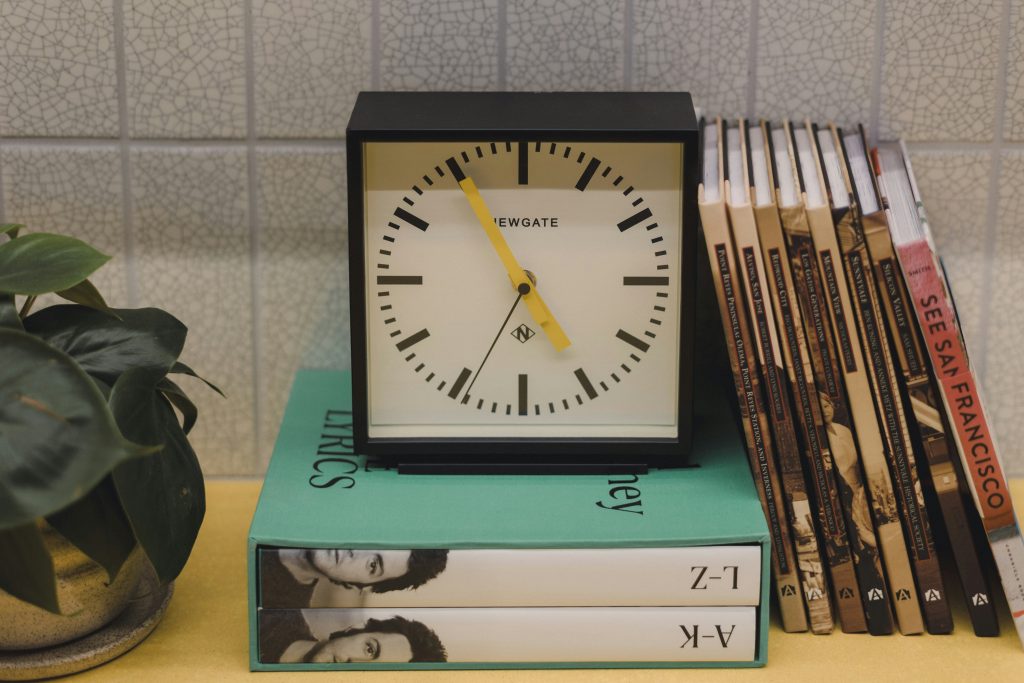 Minimalist desk with analog clock and journal.