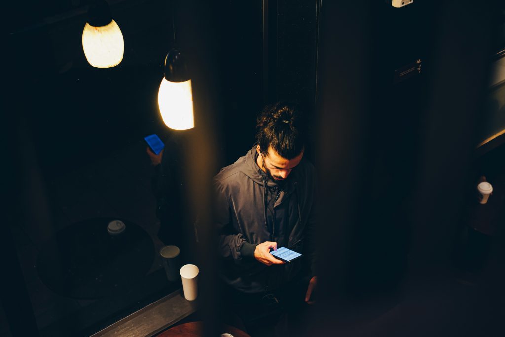 Man overwhelmed by smartphone notifications.