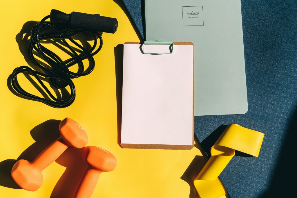 Tracking journal next to gym gear.