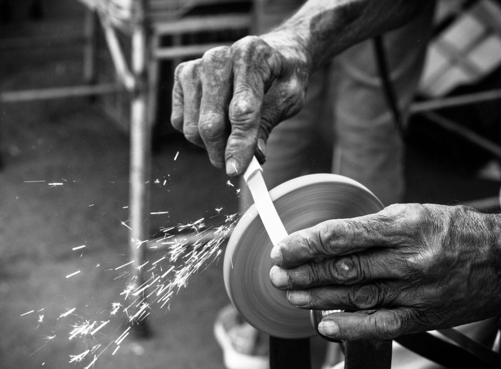 Blade being sharpened – metaphor for masculine discipline forged through struggle.