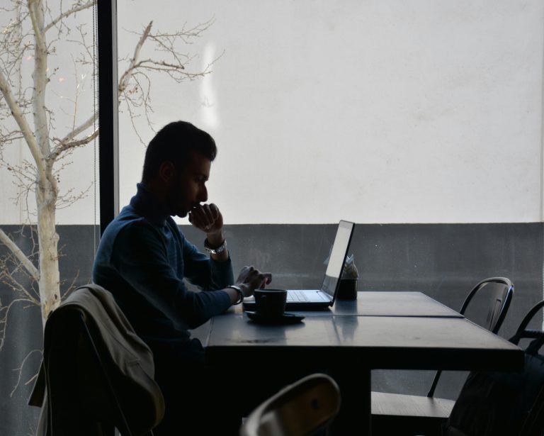Man in focused deep work session, sitting at minimalist desk for 2-hour productivity block.