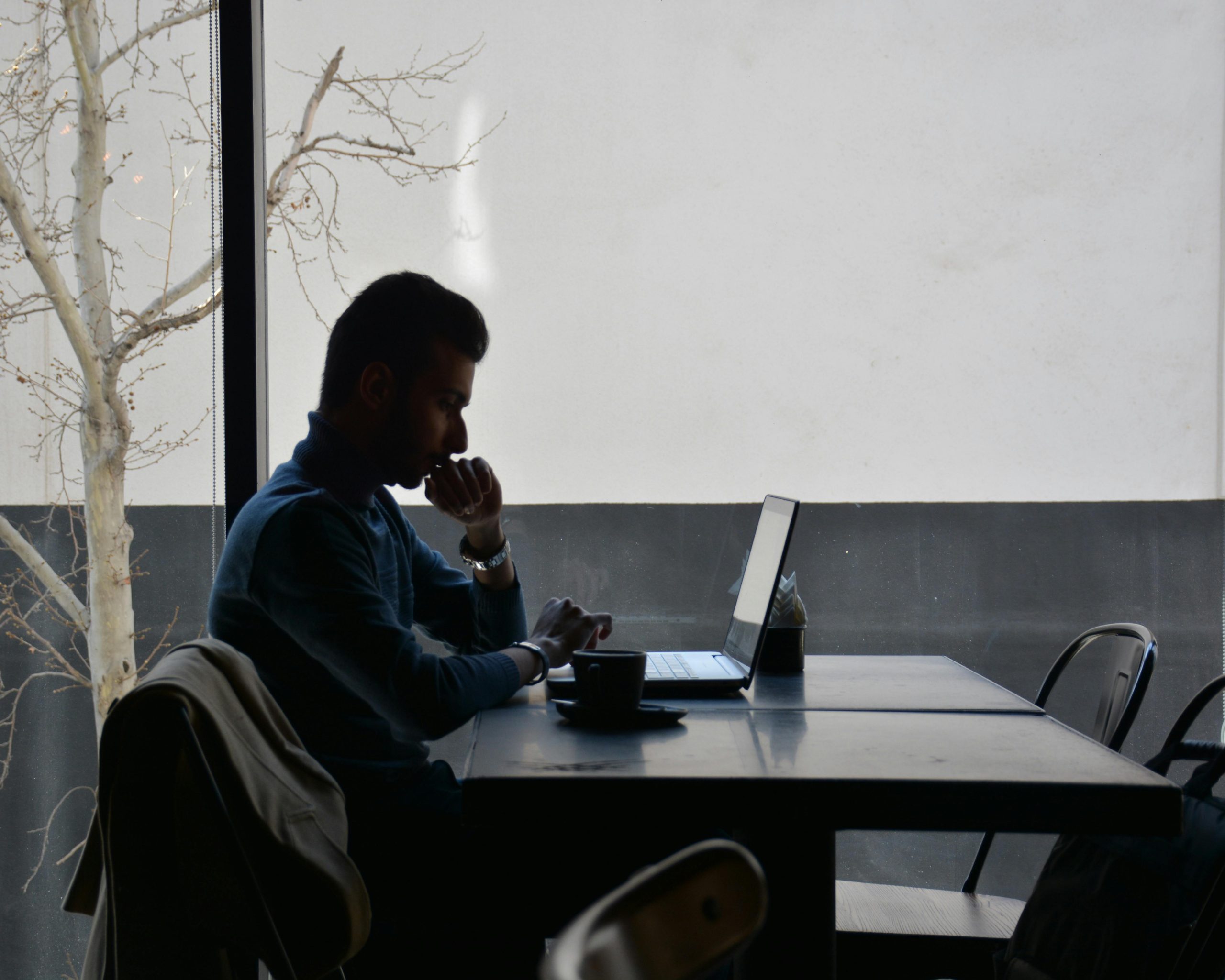 Man in focused deep work session, sitting at minimalist desk for 2-hour productivity block.