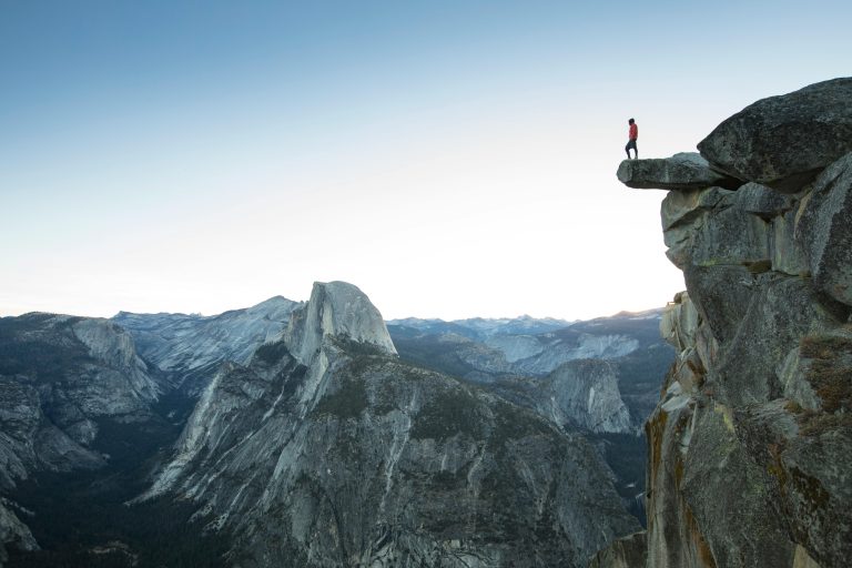 Silhouetted man regaining clarity and focus as he looks out over a vast landscape, escaping dopamine addiction and focus.