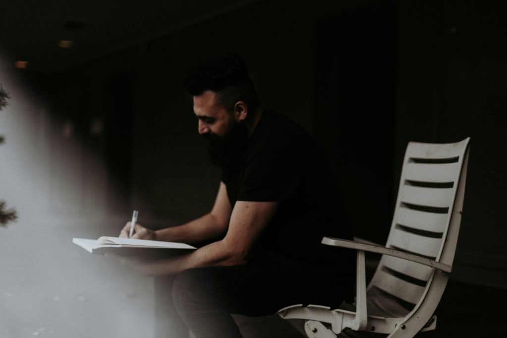 A man writing and tracking his goals in order to achieve them.