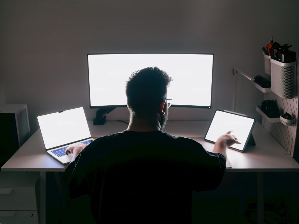 Man overwhelmed by multitasking and constant notifications leading to loss of focus.